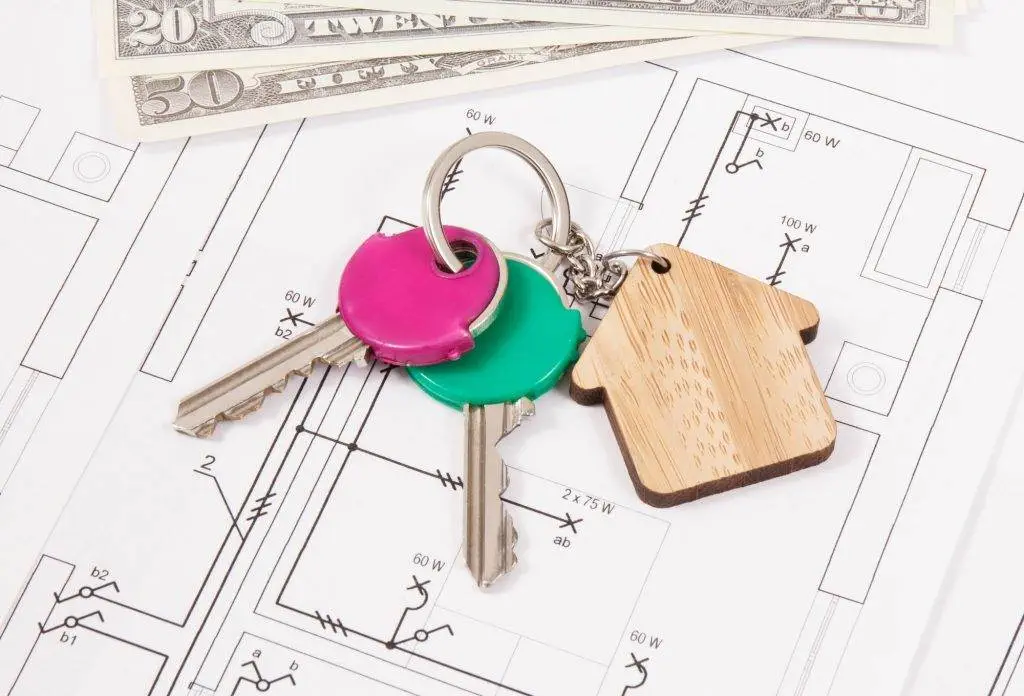 Keys with home shape and dollar on diagrams of house. Building or buying home